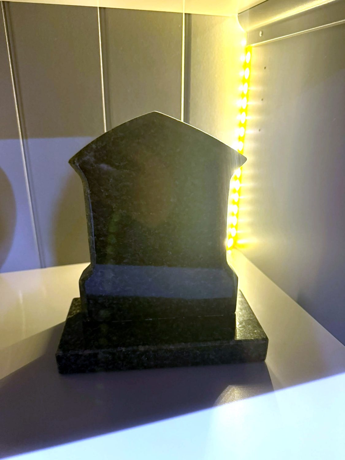 A polished green granite headstone sample in our showroom.